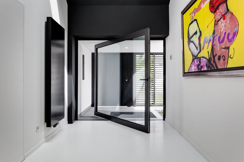 Porte pivotante en aluminium dans une villa moderne.