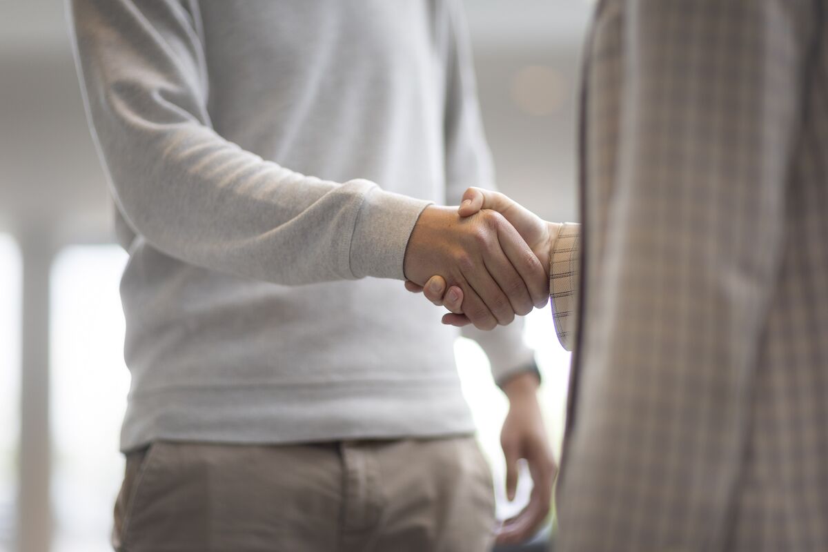 Un homme et une femme se serrant la main dans un immeuble de bureaux.