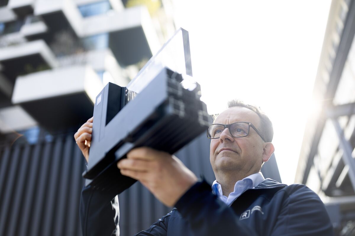 Un homme regarde un échantillon d’angle en aluminium de fenêtres dehors.
