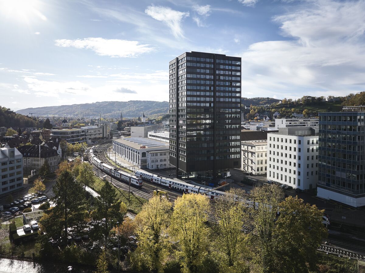 Tall black residential building next to railway in Zurich.