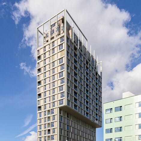 Immeuble de grande hauteur beige avec de nombreuses fenêtres au centre-ville.