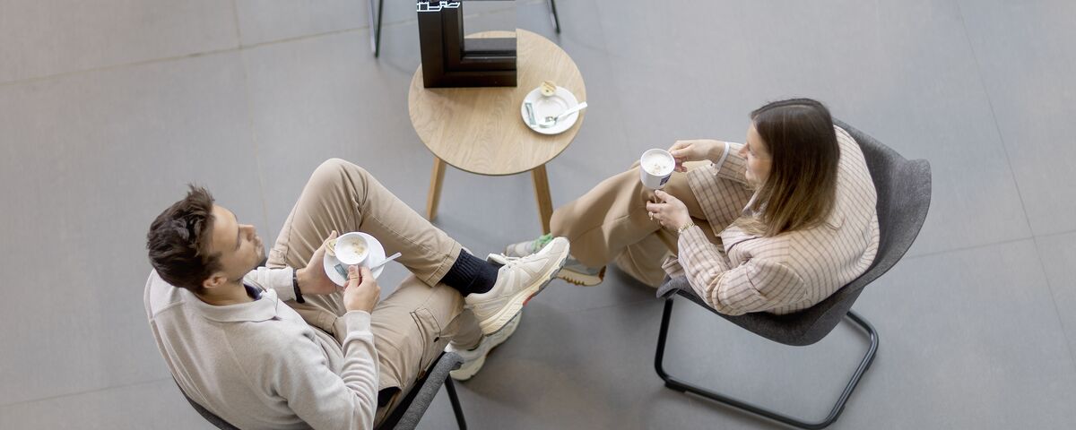 Vue d'en haut d'un homme et d'une femme assis à une table en train de boire du café.