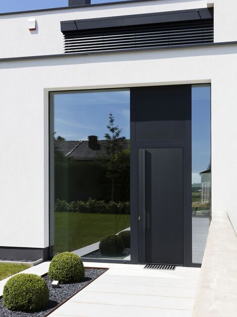 Porte à panneaux en aluminium noir dans une maison moderne.