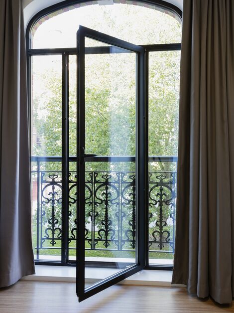 Porte de balcon SlimLine 38 s’ouvrant sur un balcon français.