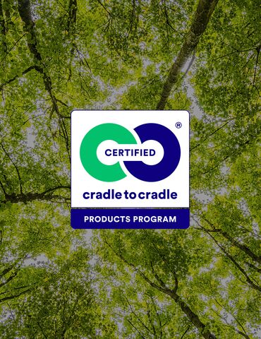 Logo Cradle to Cradle devant les cimes vertes des arbres.