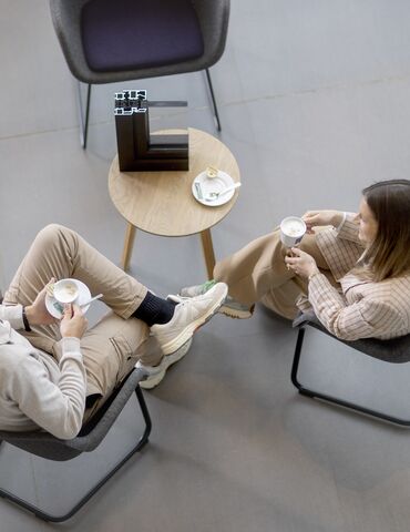 Vue d'en haut d'un homme et d'une femme assis à une table, buvant du café.