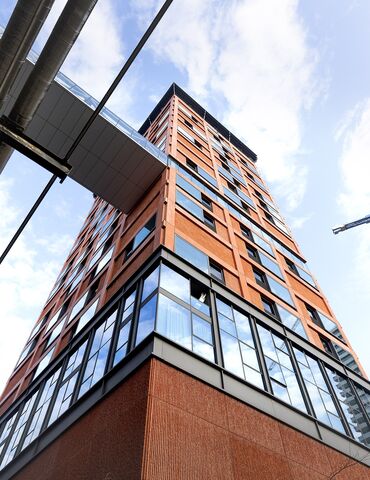 Un immeuble de grande hauteur orange vu d'en bas.