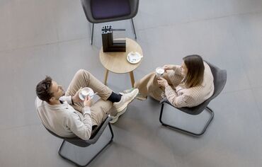 Top view man and woman sitting at table drinking coffee.