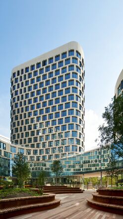 Immeuble de bureaux blanc futuriste avec des arbres à côté.